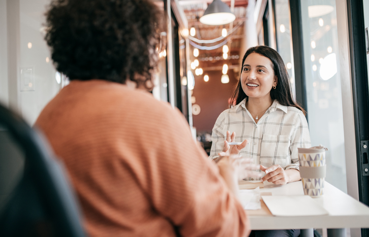 Two people talking and sitting at a table